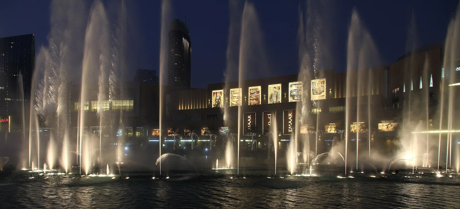 The Dubai Fountain lit up at dusk in front of The Dubai Mall