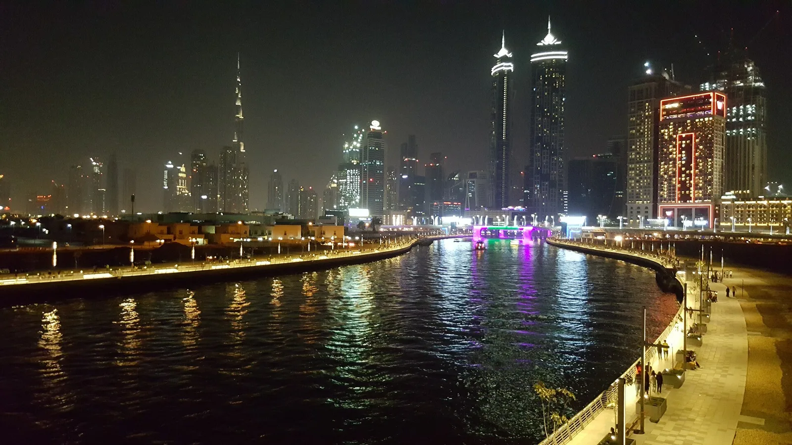 The Dubai Water Canal and its waterfront walkway lit up at night