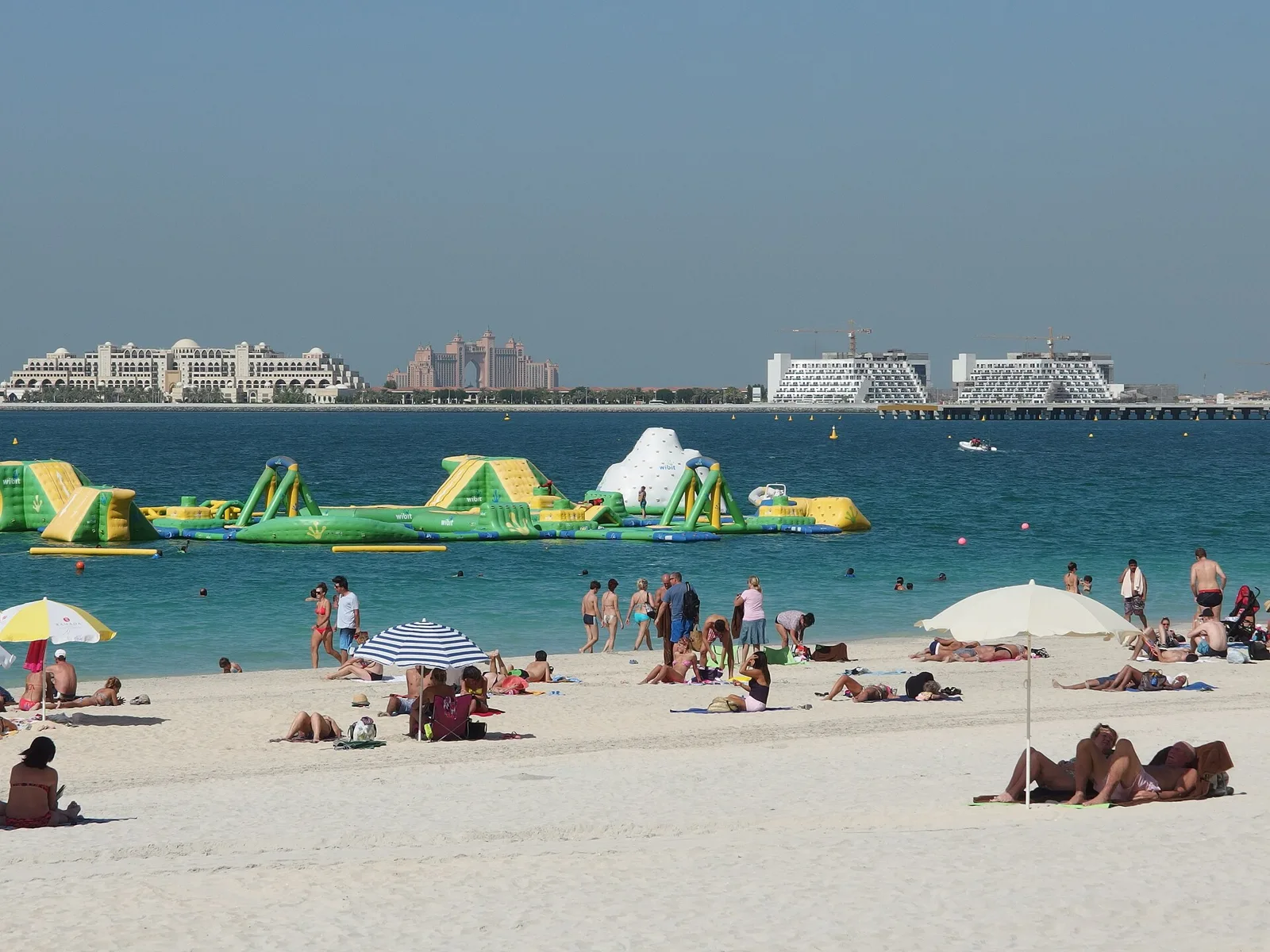 Sunbathers and umbrellas on the beach at Jumeirah Beach Residence with the sea behind